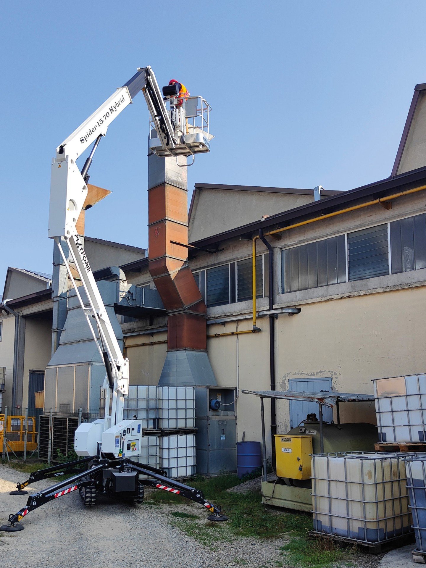 Scissor lift elevated inside an industrial steel-frame structure